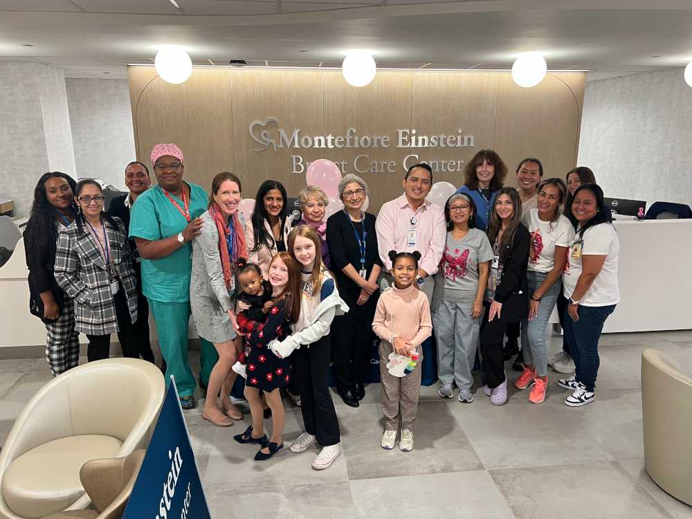 group of providers, staff, adults, and kids in front of admitting desk