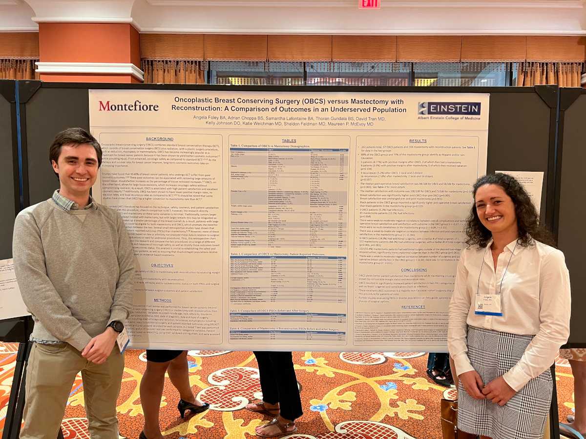 Two people in front of a conference display
