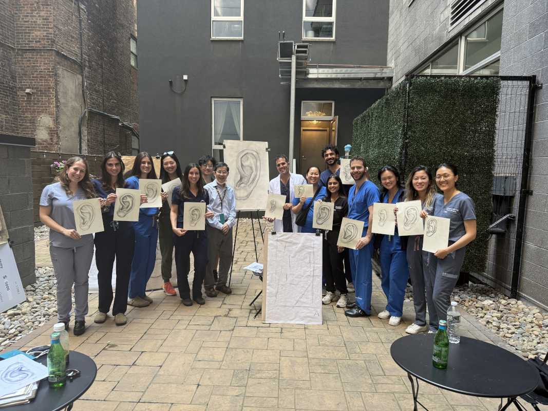 Group of providers outside holding drawings of ears