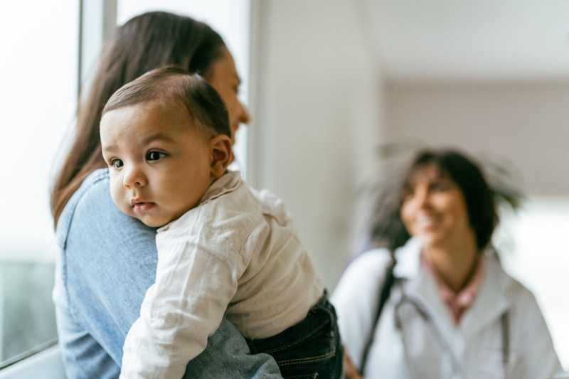 Infant being held with head resting on mother's shoulder