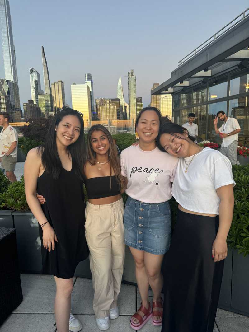 group of four people on patio in evening, with city scape behind them
