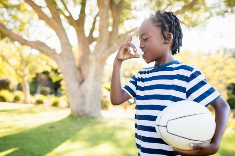 Child with ball using an inhaler 