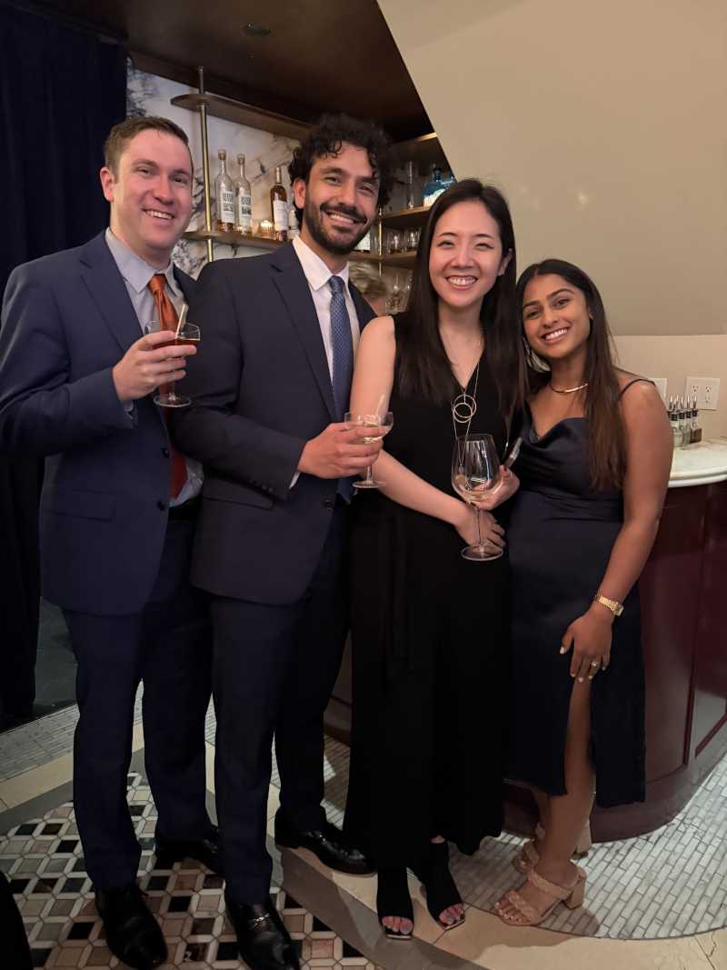 Four people posing for a photo in evening wear